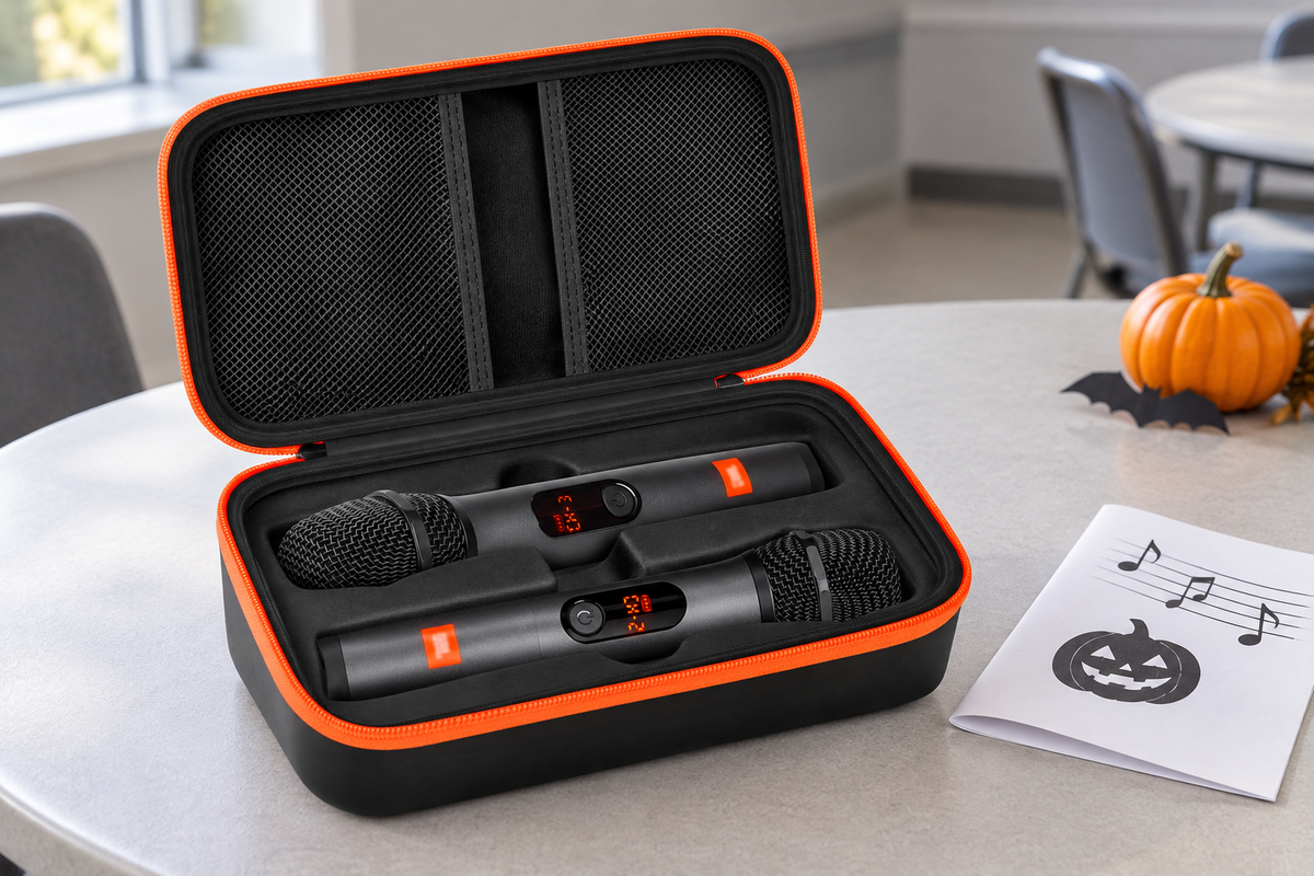 Black fitted two-microphone case with orange zipper and two mesh lid pockets on a gray karaoke preparation table.