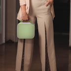 Person carrying the light green for NIIMBOT label maker case by its top handle
