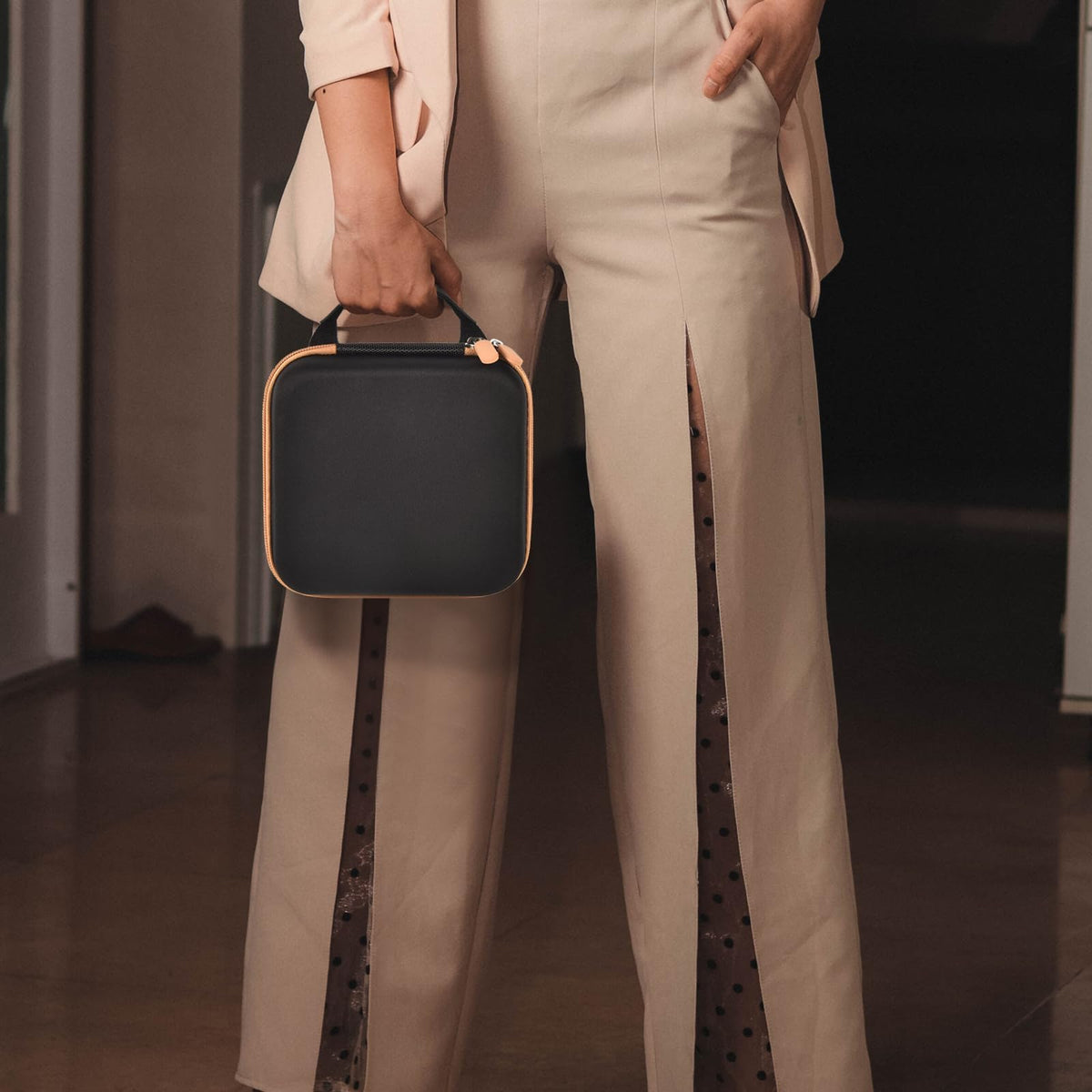 Person carrying the black and tan for NIIMBOT label maker case by its top handle