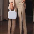 Person carrying the white and tan for NIIMBOT label maker case by its top handle