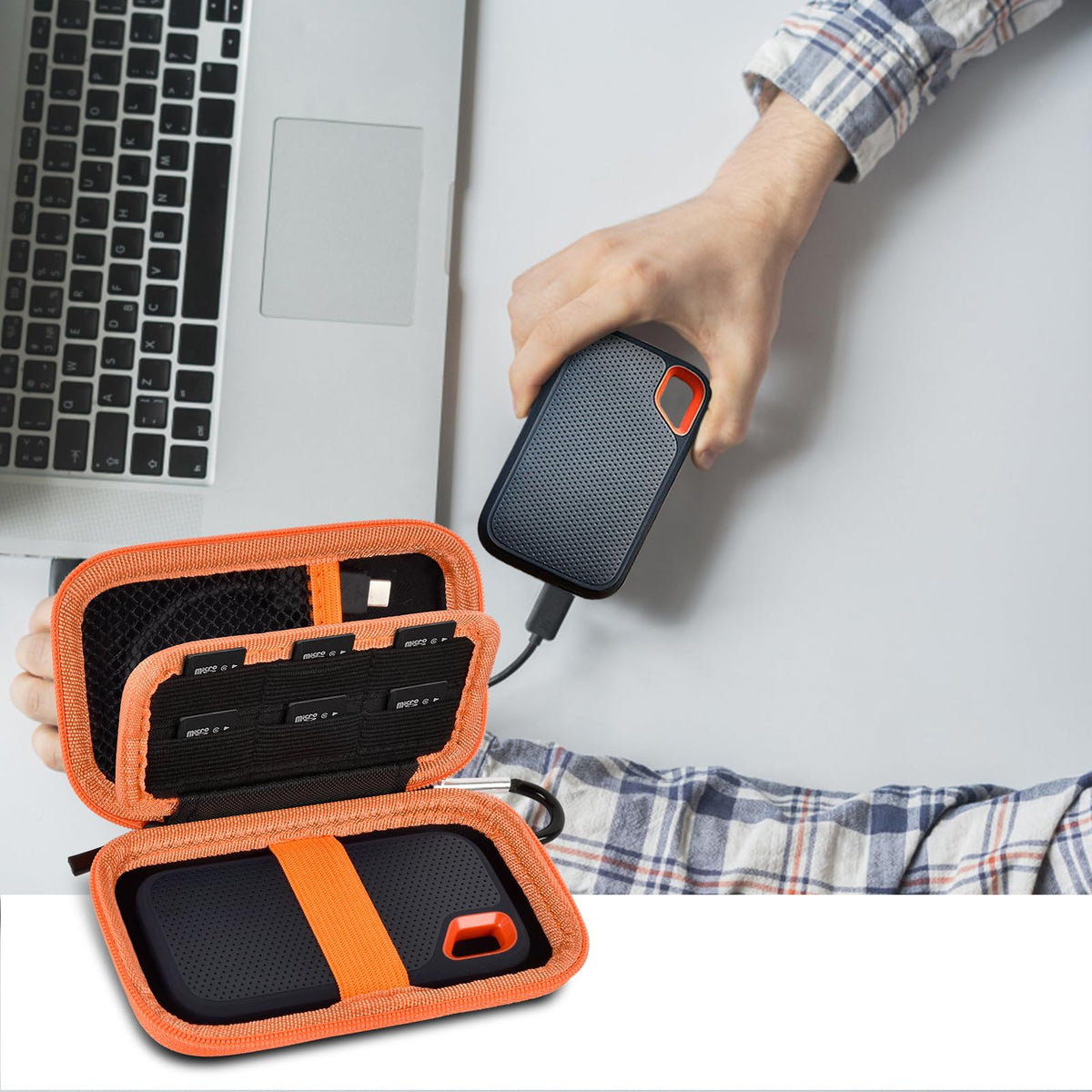 Open black and orange SSD organizer beside a for SanDisk drive connected to a laptop