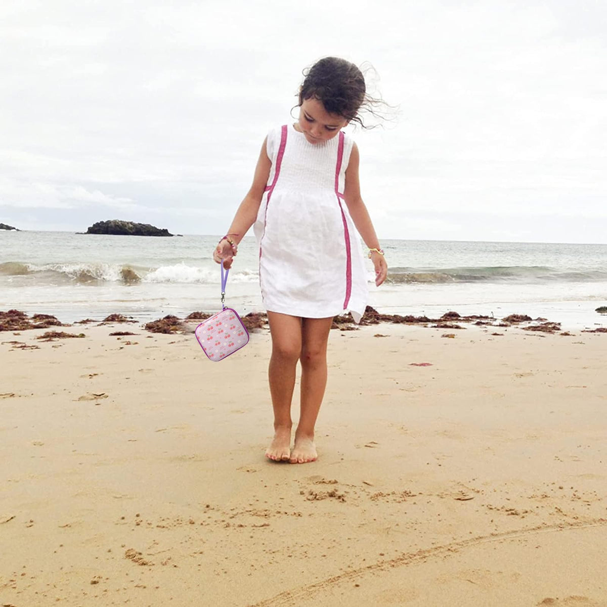Floral pink kids instant print camera case carried by a child at the beach