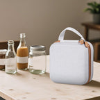 Closed white and tan for NIIMBOT label maker case beside bottles and jars
