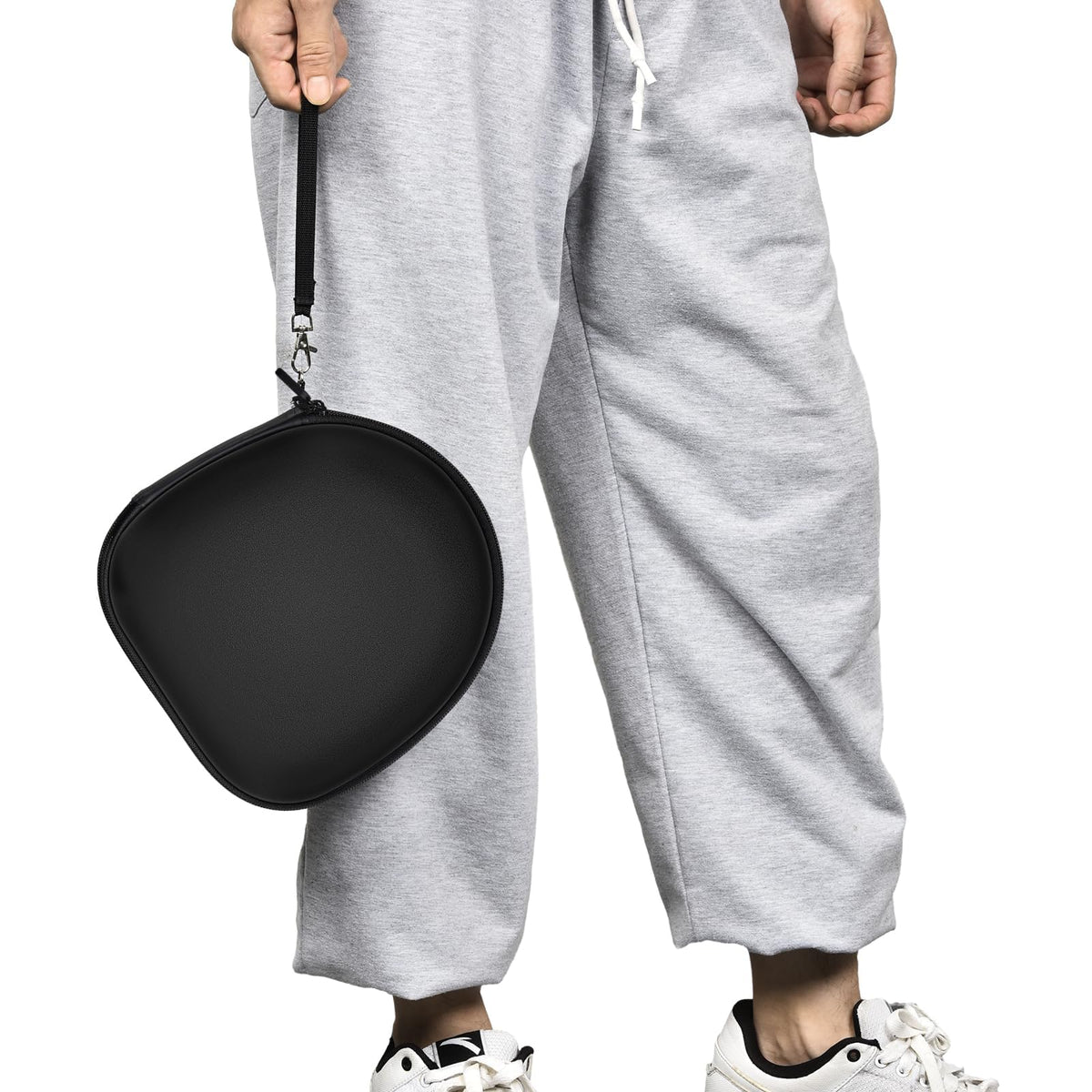 Person carrying the black headphone case by its wrist strap