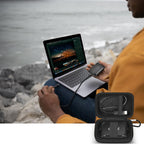 Open black SSD organizer beside a for Crucial portable drive connected to a laptop