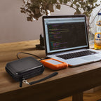 Black hard drive case beside a for LaCie Rugged Mini drive connected to a laptop