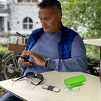 Man using a for KardiaMobile device beside the open green travel case