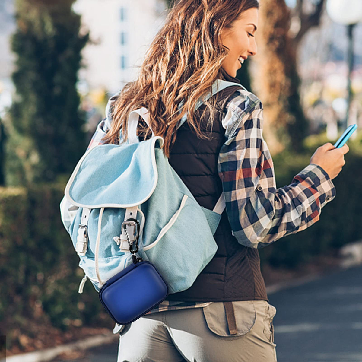 Navy blue mini power bank case attached to a backpack for travel
