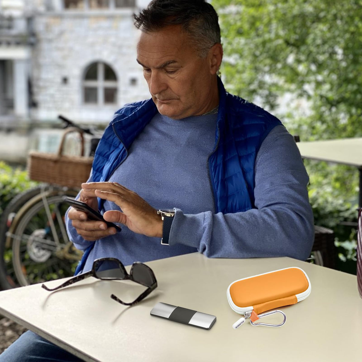 Man using a for KardiaMobile device beside the open orange travel case