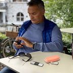 Man using a for KardiaMobile device beside the open peach travel case