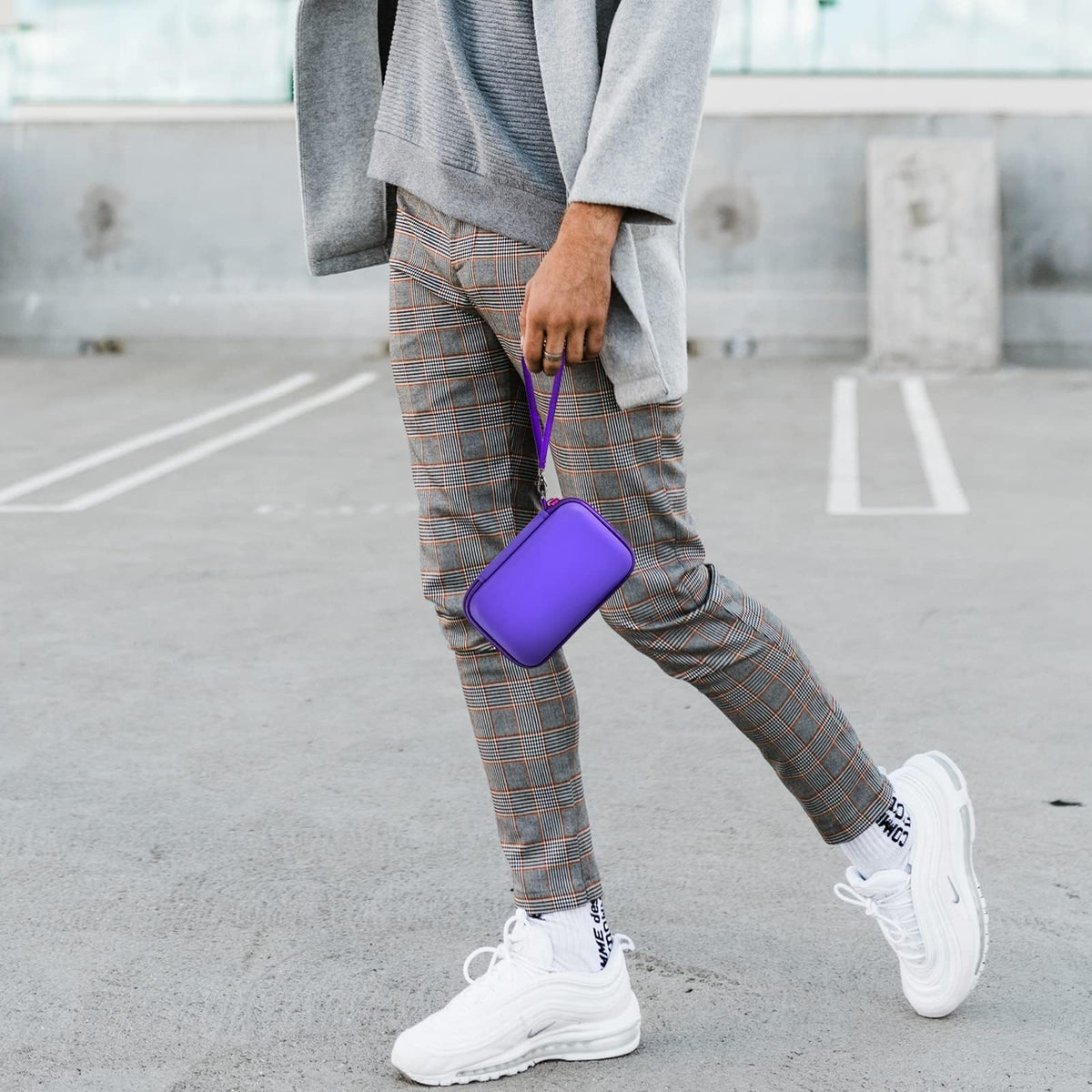 Person carrying the purple charging station case by its wrist strap