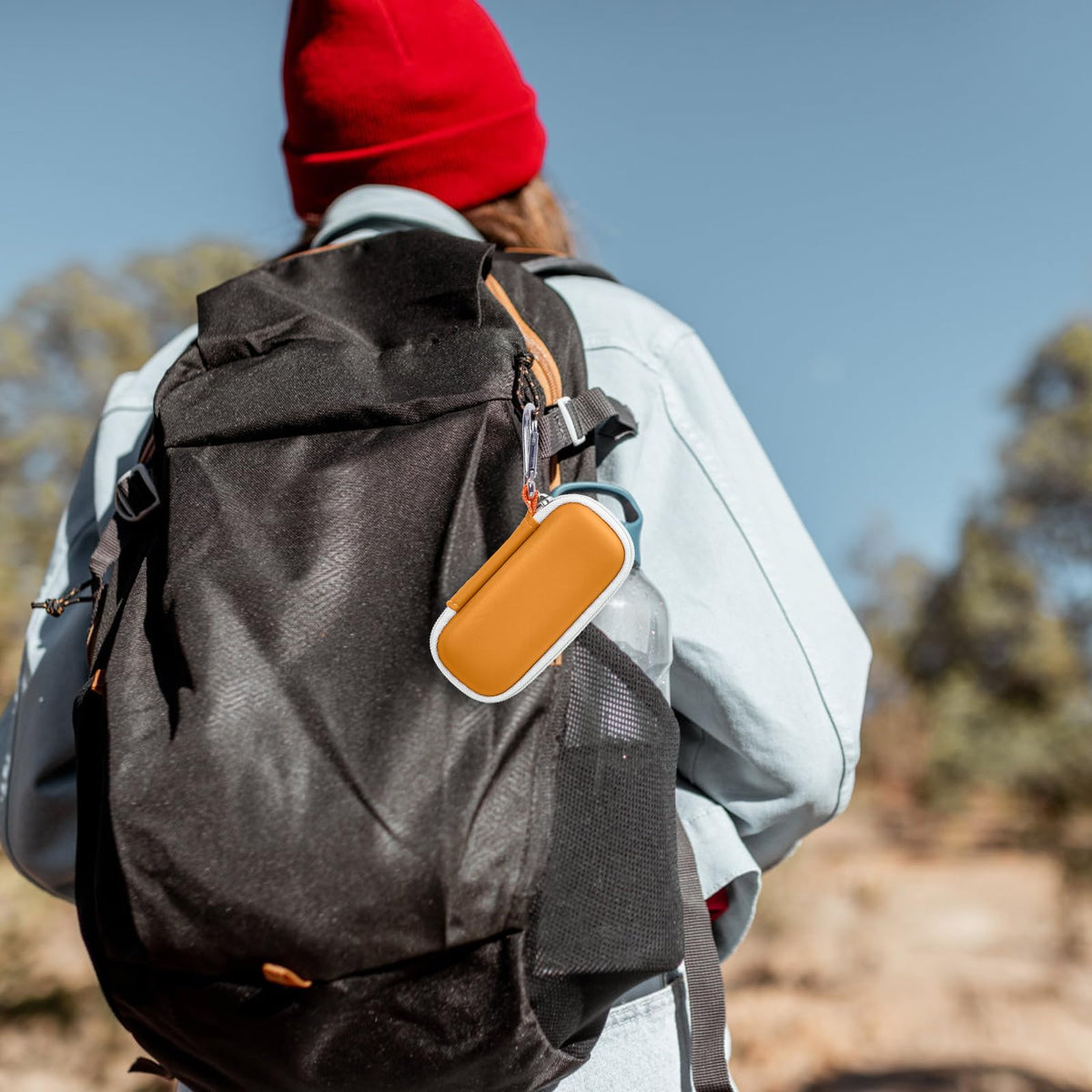 Orange for KardiaMobile case clipped to a hiking backpack