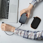 Black and orange SSD organizer beside a for SanDisk drive connected to a laptop