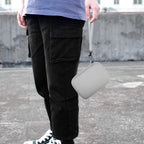 White retro handheld console carrying case carried by the wrist strap outdoors