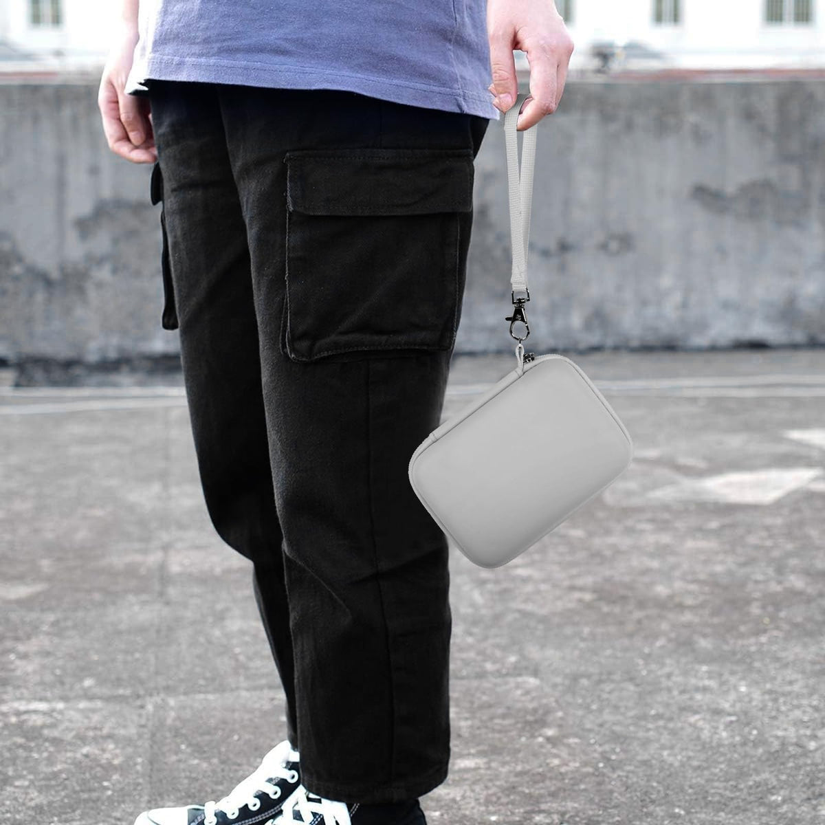 White retro handheld console carrying case carried by the wrist strap outdoors