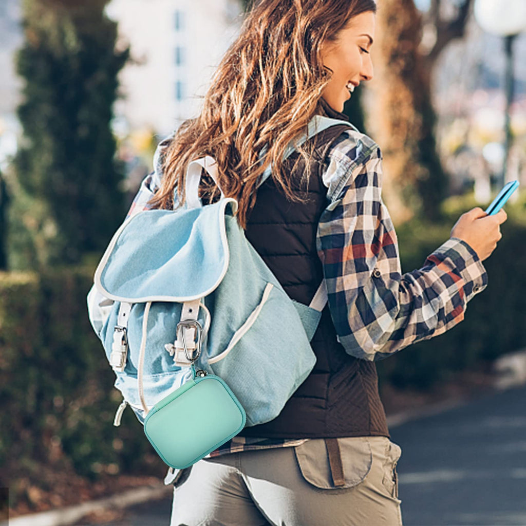Mint green mini power bank case attached to a backpack for travel