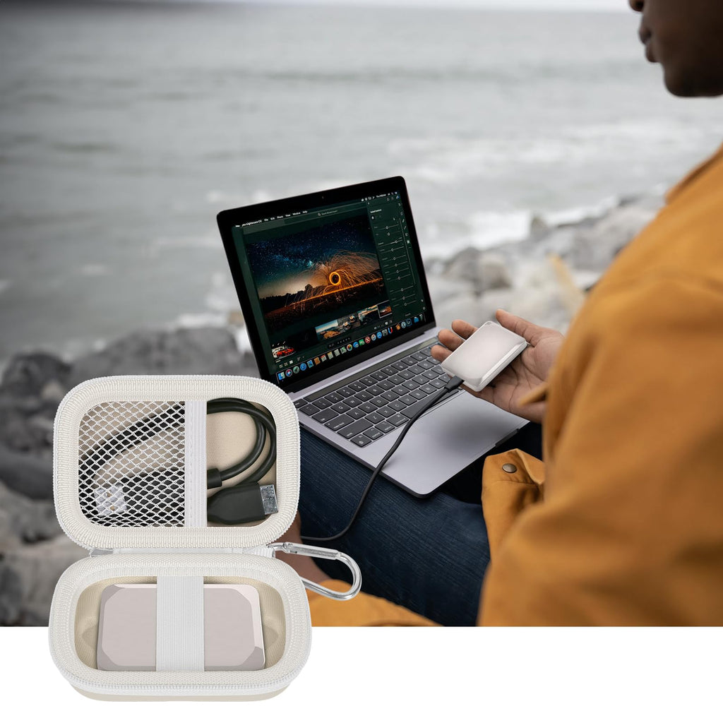 Open ivory SSD organizer beside a for Crucial portable drive connected to a laptop