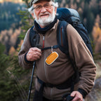 Hiker carrying the orange for KardiaMobile case on a backpack strap